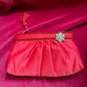 Statement piece satin style purse in true red boasts snowflake broach and beads.